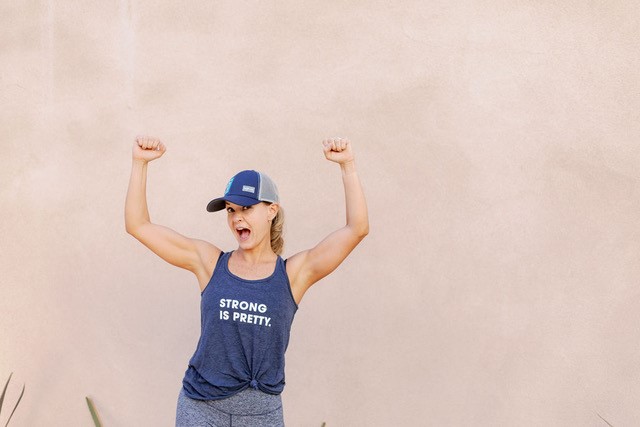 Photo of Erin Paruszewski with raised arms in victory stance and fun open-mouth expression of happiness